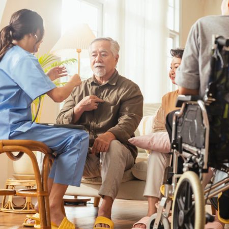 happiness-cheerful-elderly-woman-men-talking-with-female-caregiver-nurse-doctor-having-health-checking-consult-living-areacaretakers-with-senior-couple-sitting-living-room-nursing-home