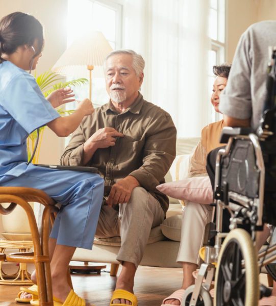 happiness-cheerful-elderly-woman-men-talking-with-female-caregiver-nurse-doctor-having-health-checking-consult-living-areacaretakers-with-senior-couple-sitting-living-room-nursing-home